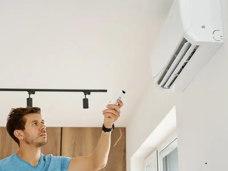 Mise en marche d'une climatisation murale à la télécommande depuis la pièce