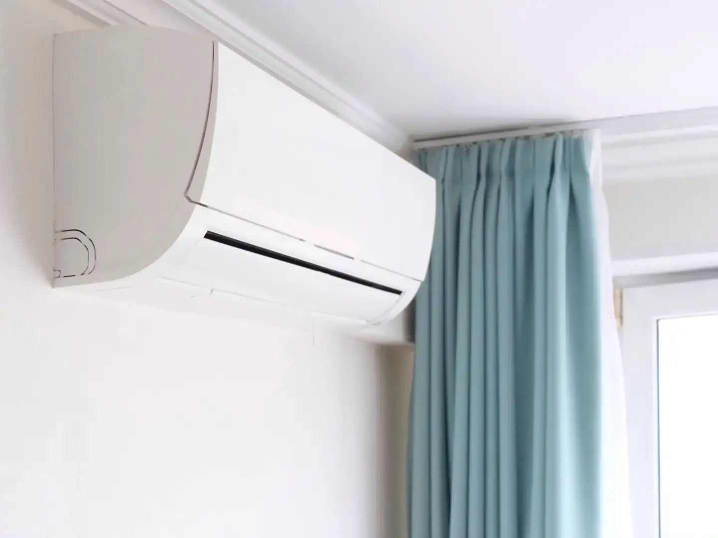 Climatiseur mural installé en haut du mur d'une chambre