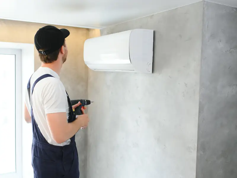Technicien posant une unité murale de climatisation à Cannes